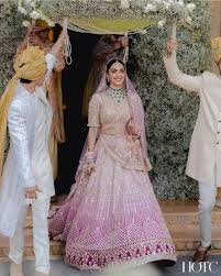 Bride entering mandap under floral canopy with family