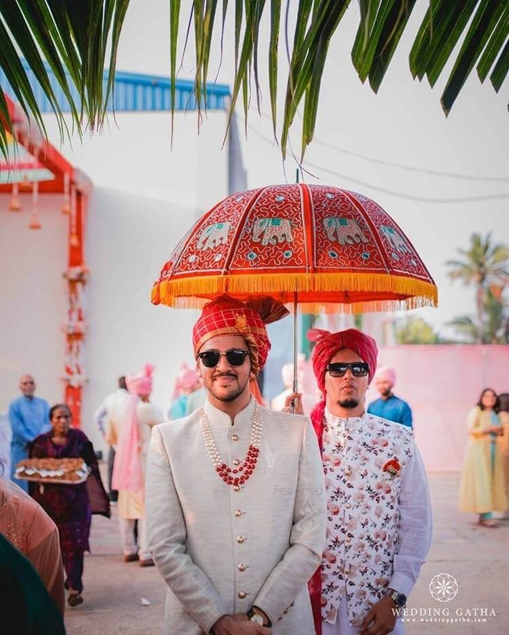 Groom making a stylish entry with sunglasses and floral décor at an Indian wedding