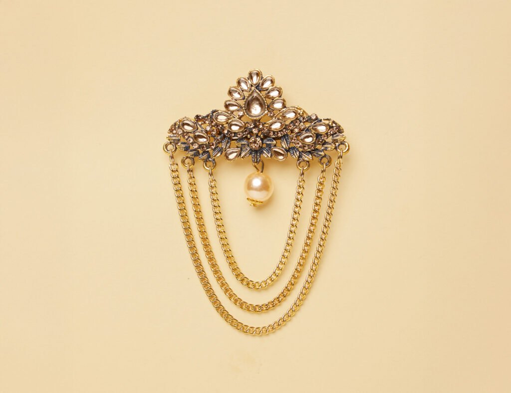 Gold pearl-layered brooch adding richness to groom sherwani