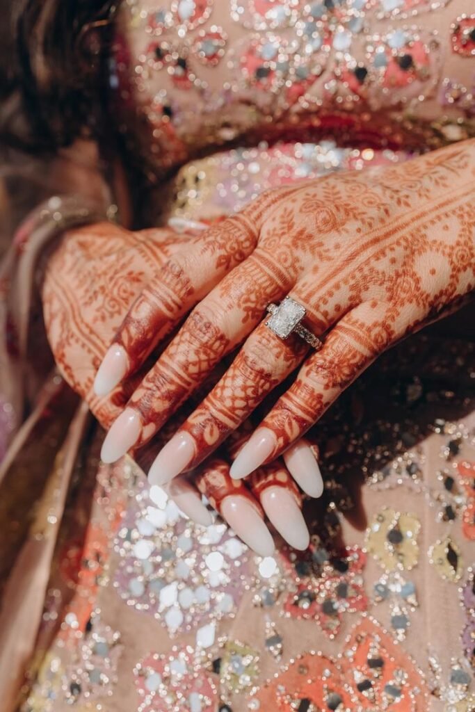 Bridal mehndi design highlighting engagement ring and nail art