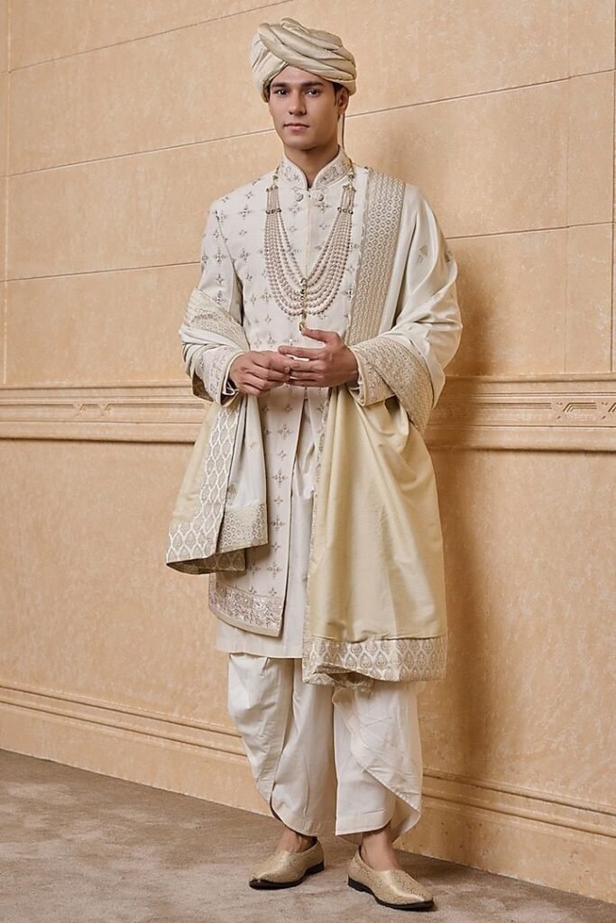 Stylish Indian groom wearing a modern ivory sherwani in 2026.